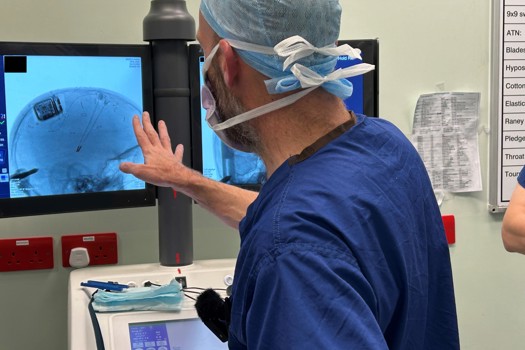 Clinician observing MRI scans showing surgical implantation of the Picostim device and electrodes