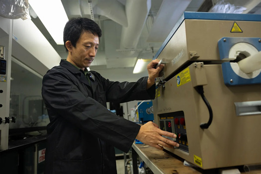 Prof Yang works with a device that helped develop his triple-phase system that captures and converts carbon dioxide
