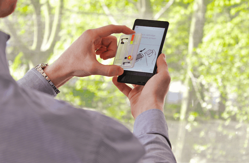 The user adds a sample and positions the transparent test cartridge on the smartphone touchscreen. The phone app then confirms the correct positioning, starts the test and prompts the user to carry out specific actions