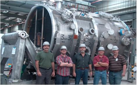 Members of the general Atomics team pose in front of one of the four neutral beam injector housings.