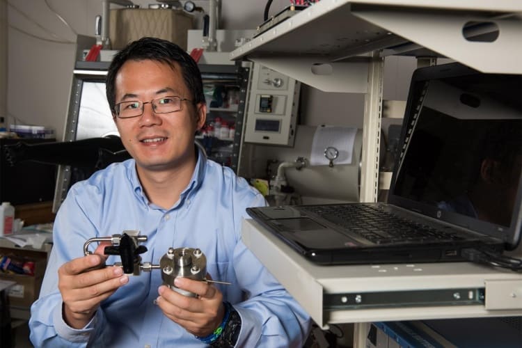 Yiying Wu, professor of chemistry and biochemistry at The Ohio State University, with an early prototype of the solar battery under development in his lab.