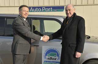 David Weir, right, director of the University of Delaware’s Office of Economic Innovation and Partnerships (OEIP) shakes hands with Dick Johnson, director of business development at AutoPort. The company is the first licensee of UD’s vehicle-to-grid (V2G)
