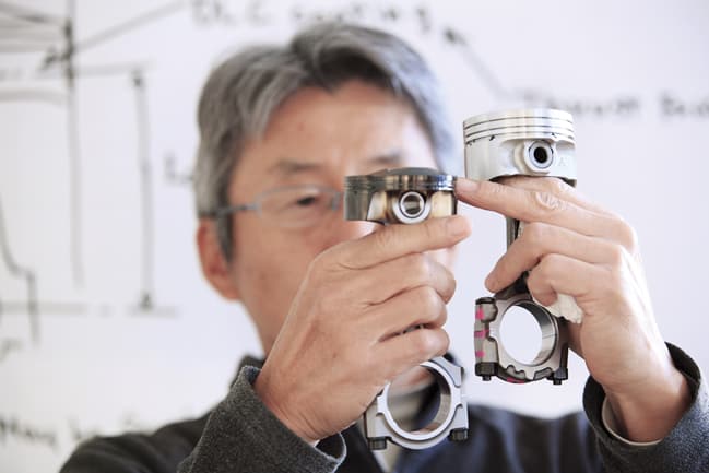 Hidehito Ikebe of Geo Engineering demonstrates how the piston heads and rods for the Projecxt M engine were resized to improve efficiency