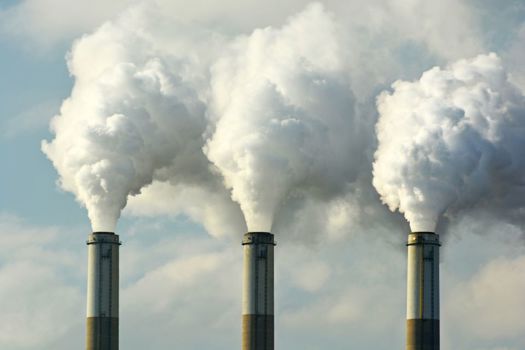 Multiple coal fossil fuel power plant smokestacks 