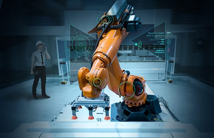 Orange automated robotic arms grabbing and lifting boxes of electronic appliances.