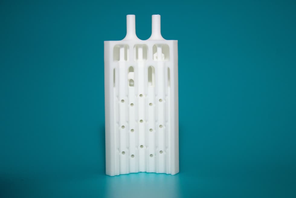 Cut through a ceramic microreactor which was manufactured additively: the complex channels as well as the fluidic connections at the top were printed together with the whole component. © Fraunhofer