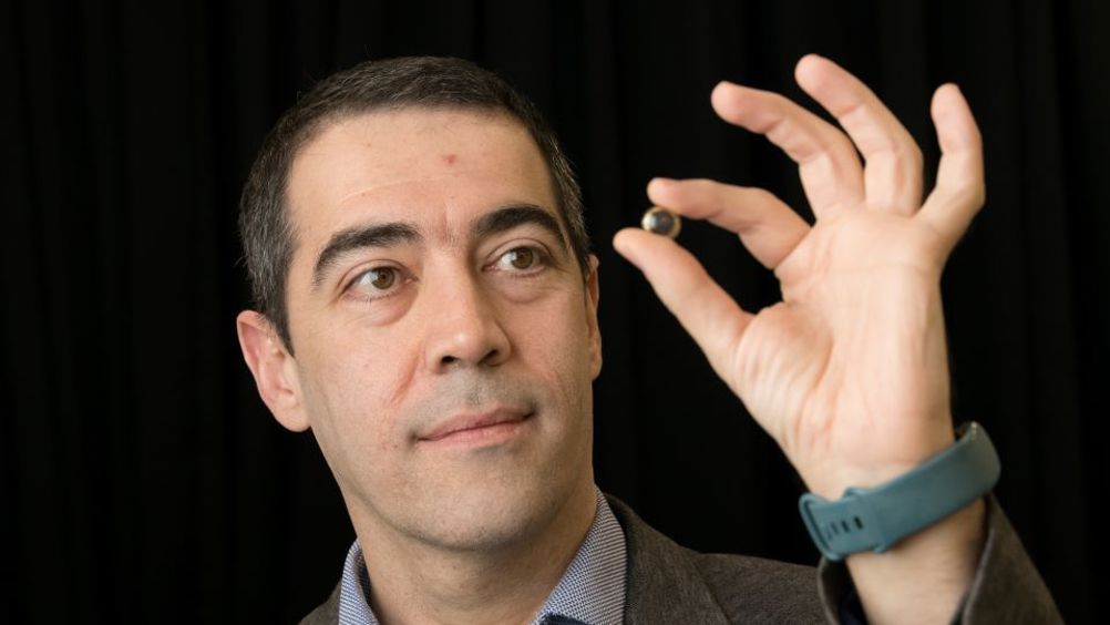 Professor Hamdi Torun pictured holding the contact lens