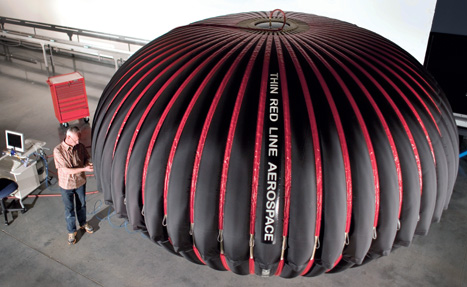 Design engineer Maxim de Jong inspects the five meter CAES Energy Bag during initial test inflation at Thin Red Line Aerospace in Canada.