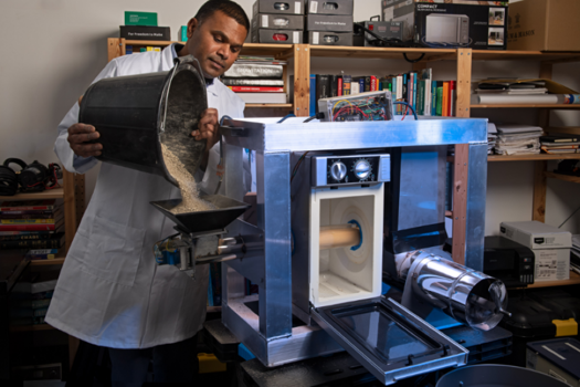 This prototype of a lunar regolith processing system has been built using a BBQ wood pellet feeder on the left, a domestic microwave oven in the middle, and an auger on the right, with building sand used as a lunar regolith simulant